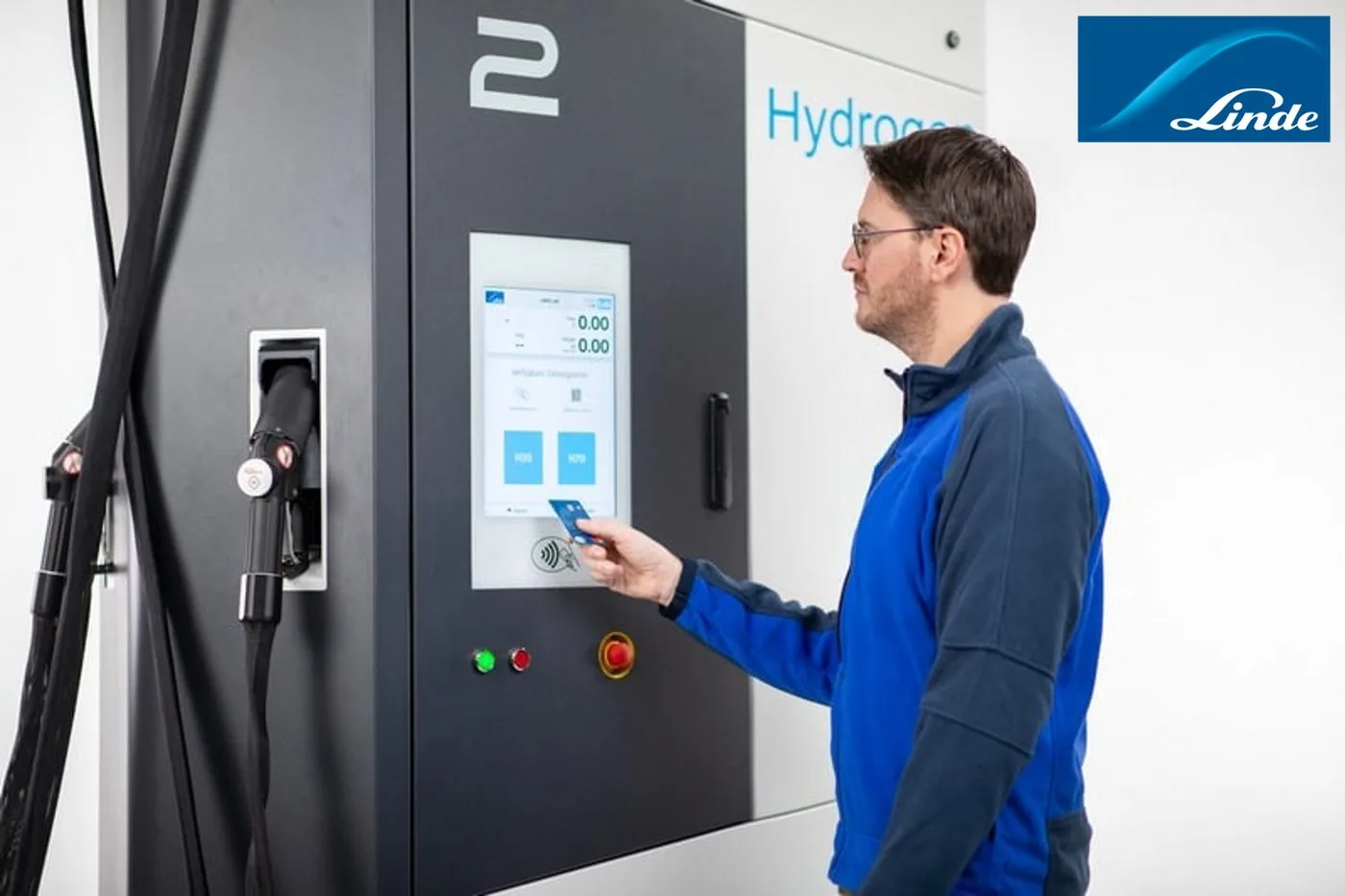 A technician tapping a payment badge on a VCID-equipped hydrogen dispenser, on site